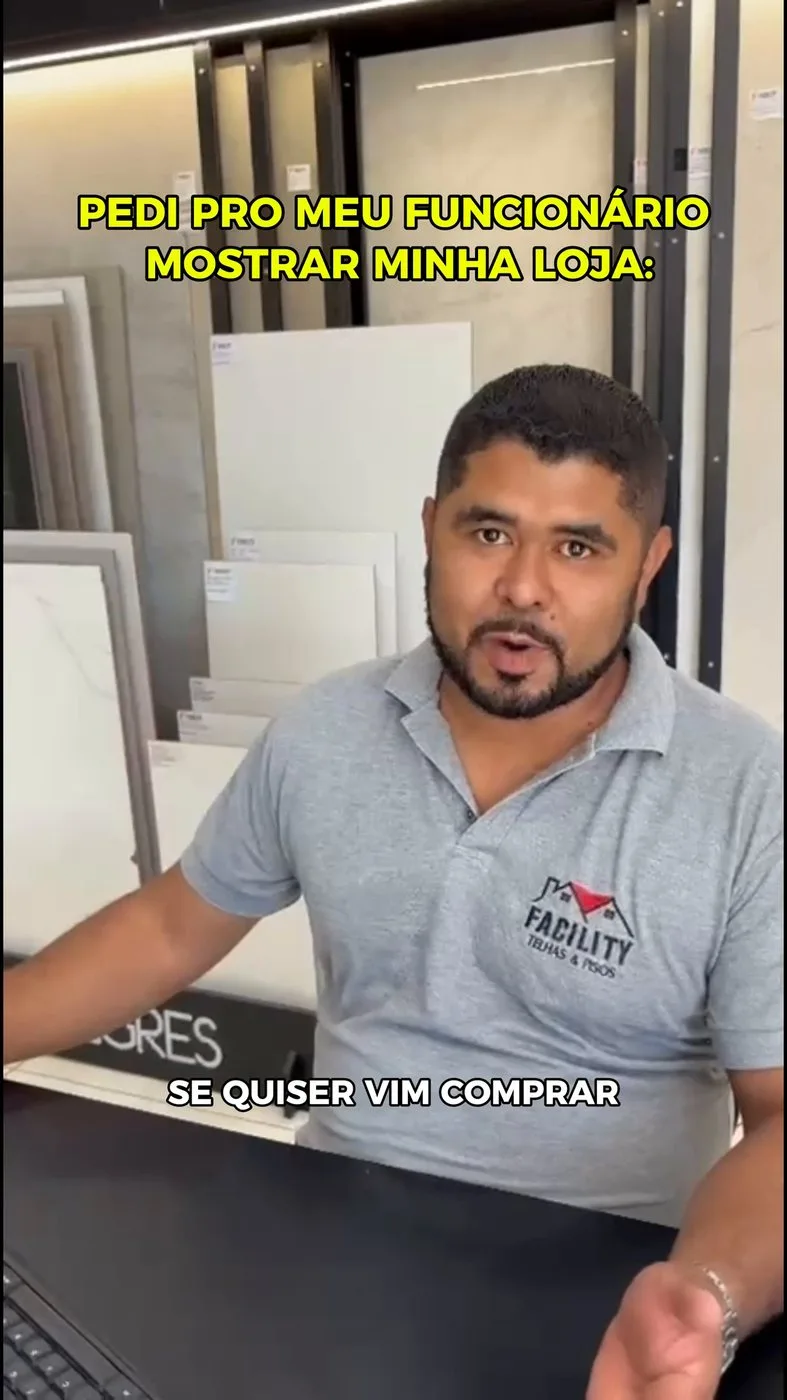 Vendedor da Facility no balcão do showroom, entre as placas de porcelanato