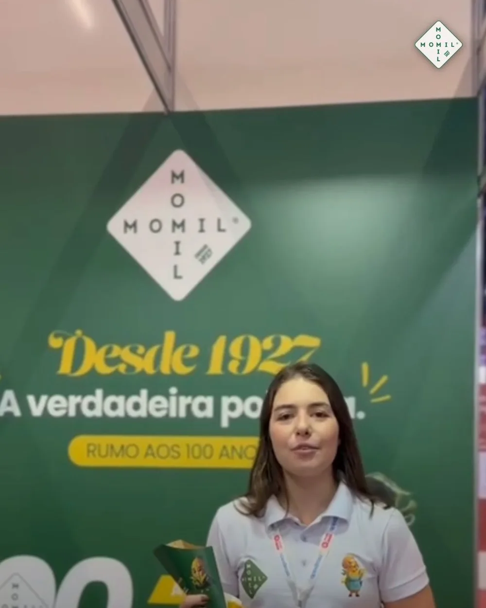 Beatriz, da Momil, com o cone de degustação diante da parede do stand