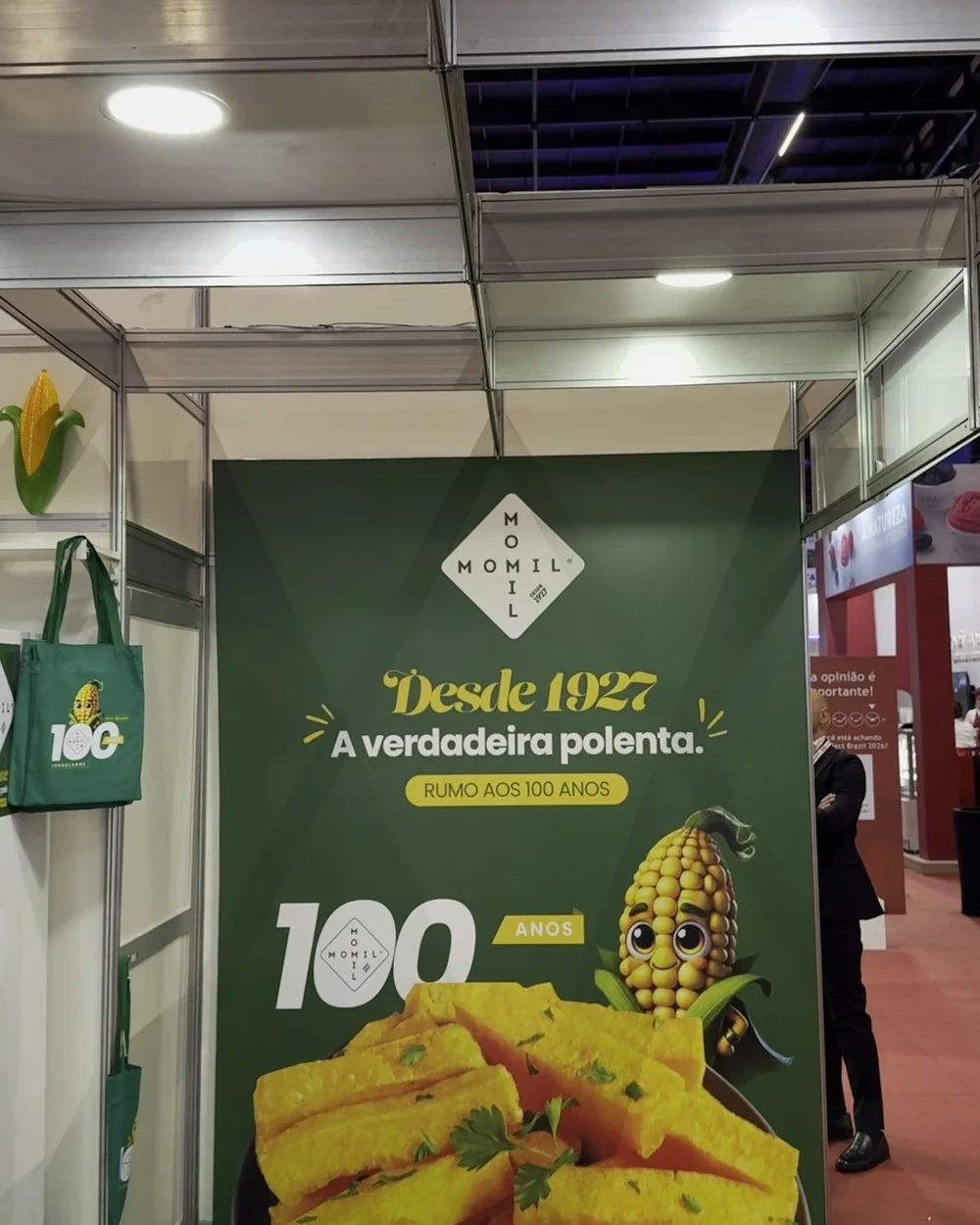 Parede de fundo e display do stand, com o selo dos 100 anos