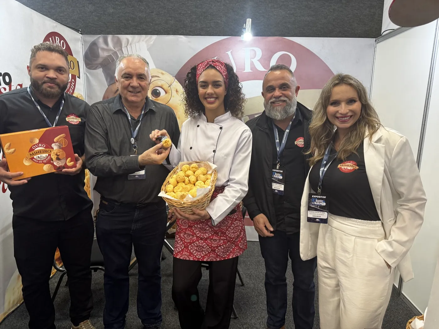 A equipe da Ouro Mineiro no estande da feira Encatho, em agosto de 2026, com o Dom na comunicação visual